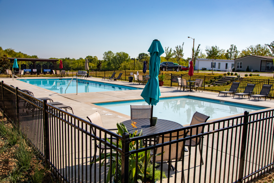 A swimming pool surrounded by lounge chairs in a manufactured home community