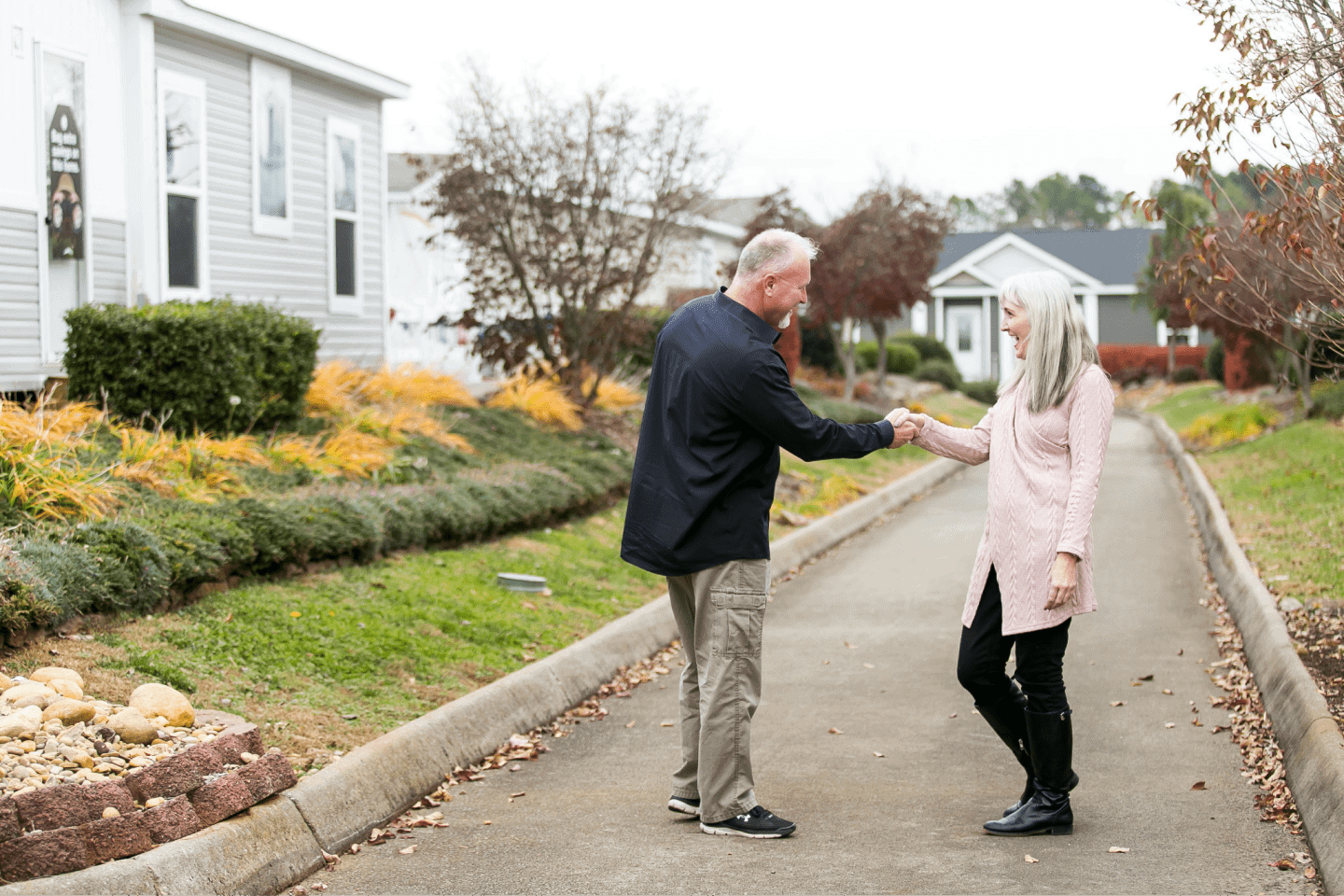 ActiveAdultHomeSale 1-min Elderly couple shaking hands in neighborbood