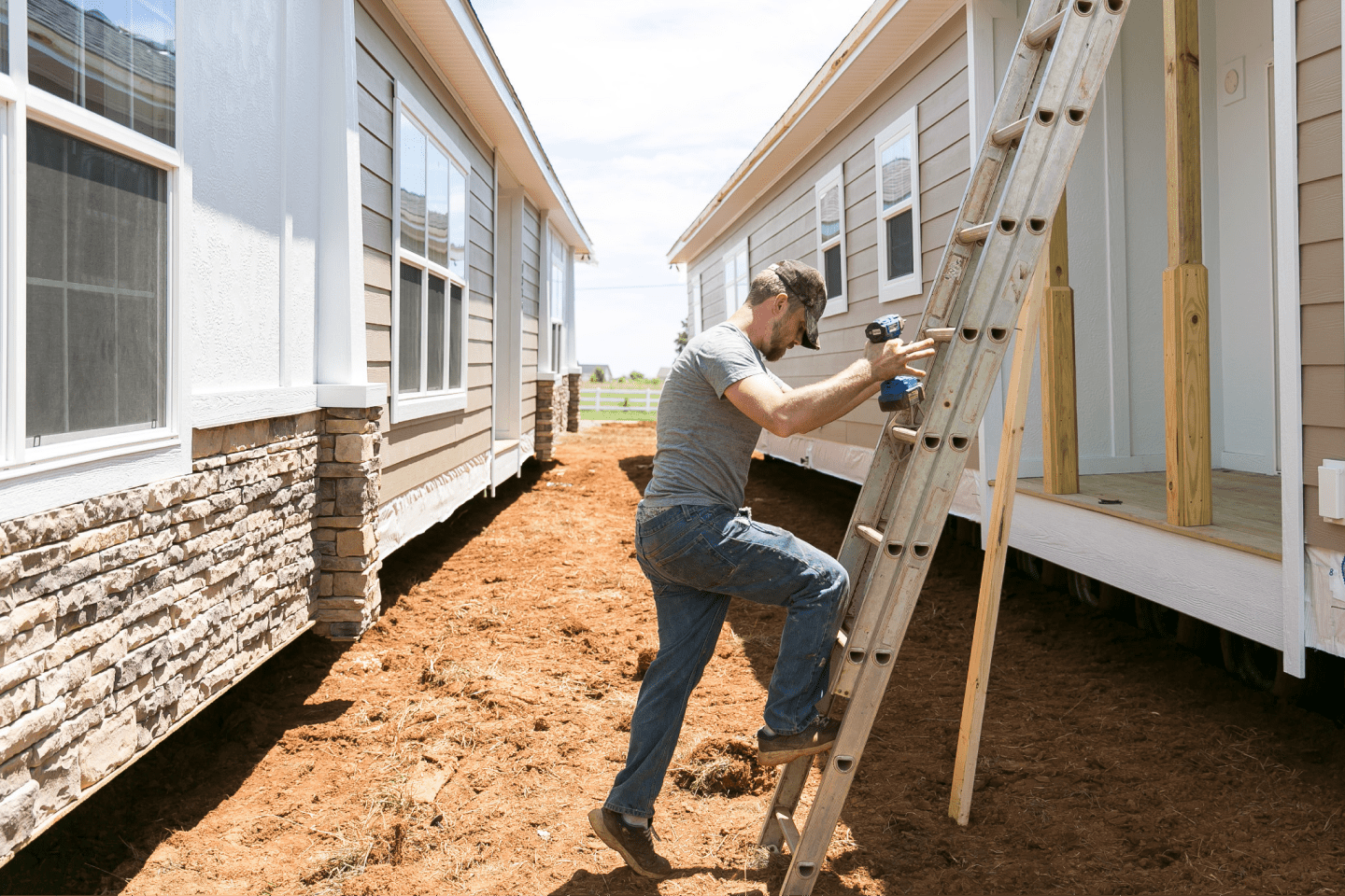 Man climbing ladder building manufactured home Man climbing ladder building manufactured home