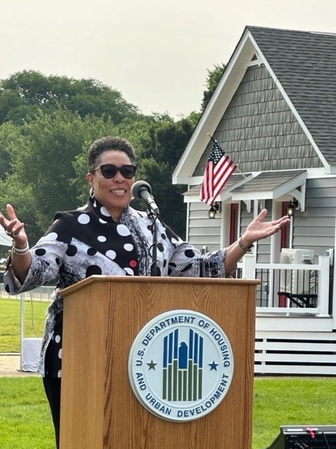 Woman speaking in front of manufactured home