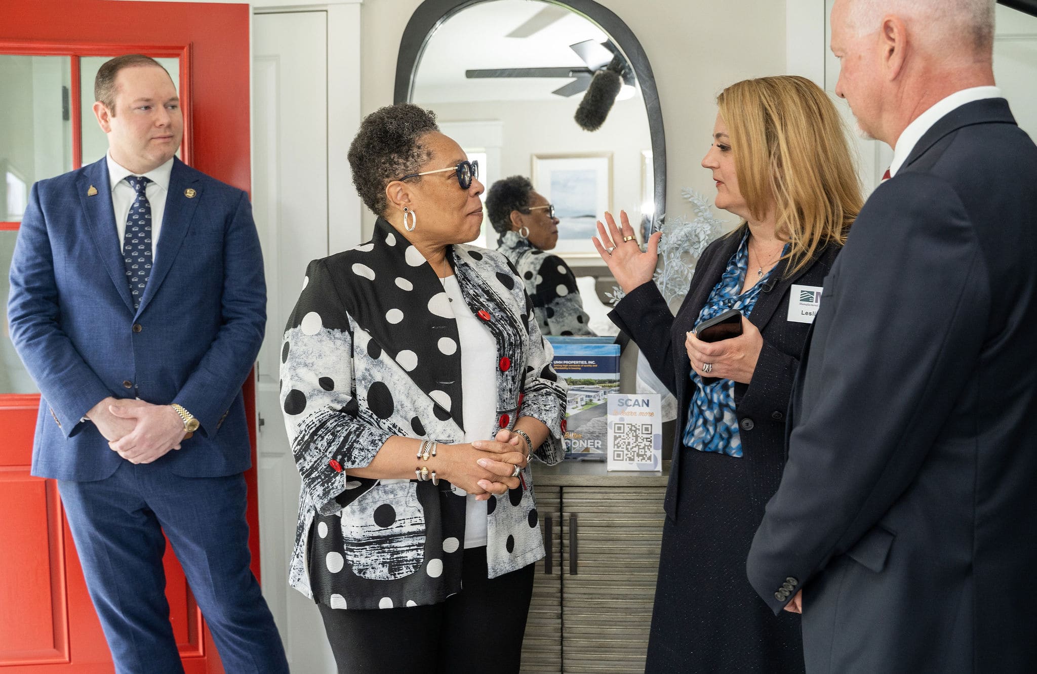 Group in business attire chatting inside manufactured home
