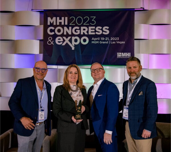 Group of four taking a picture with an award