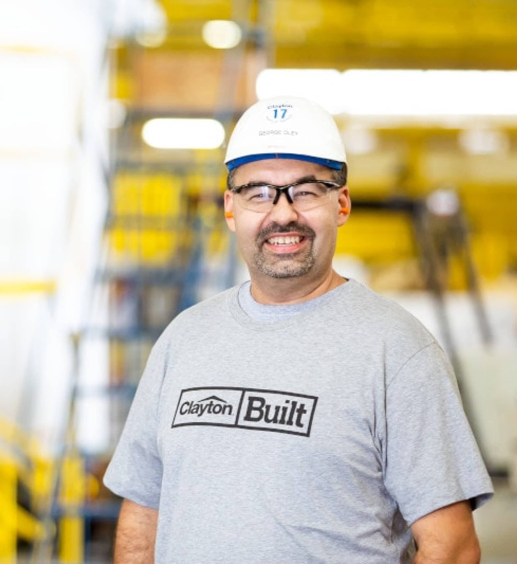 Man smiling in front of camera with safety hat on