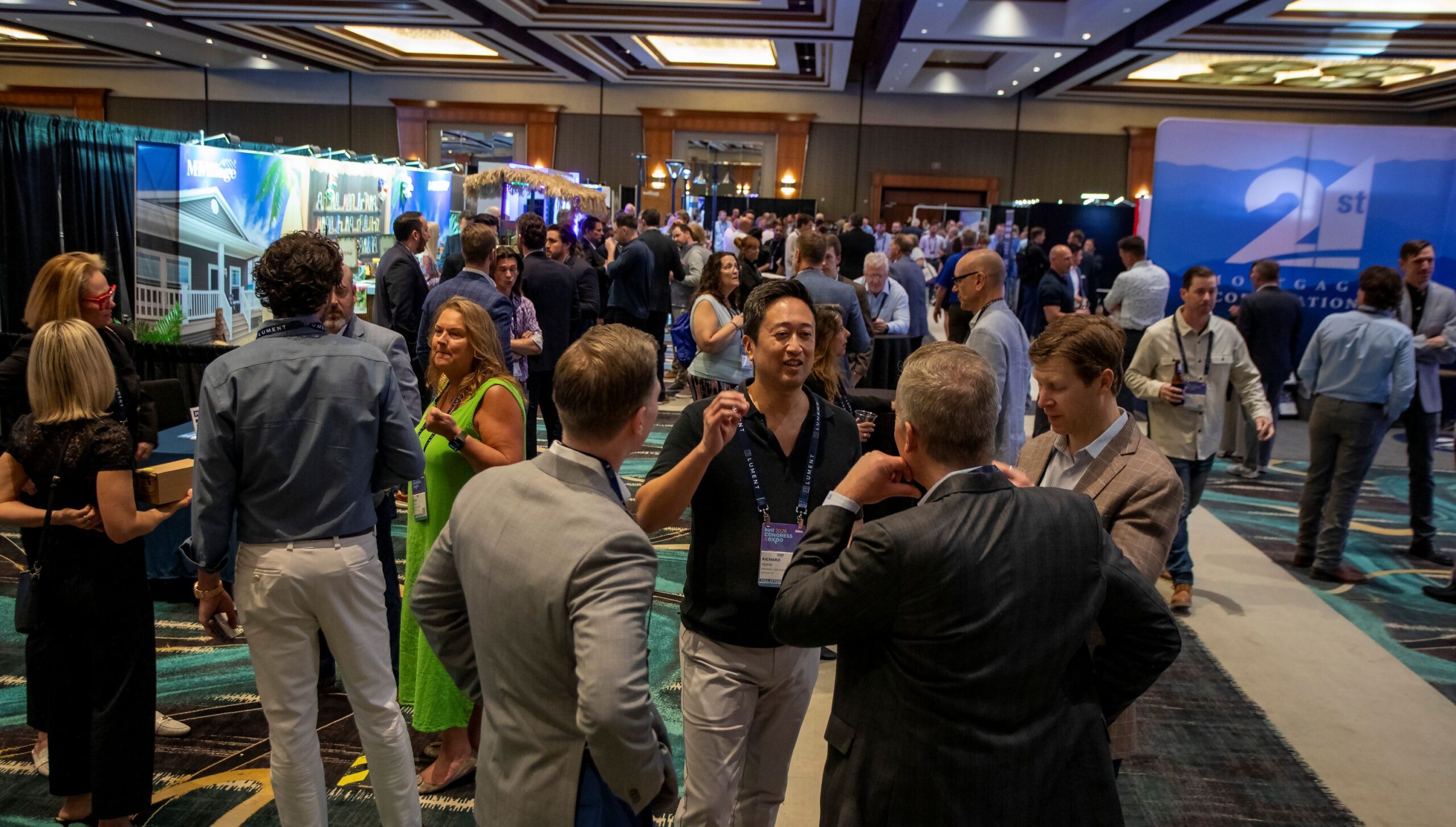 People networking and talking on a busy conference show floor.