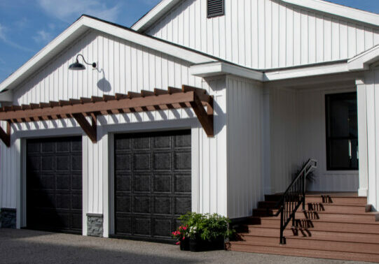 A white manufactured home with a 2 door garage attached